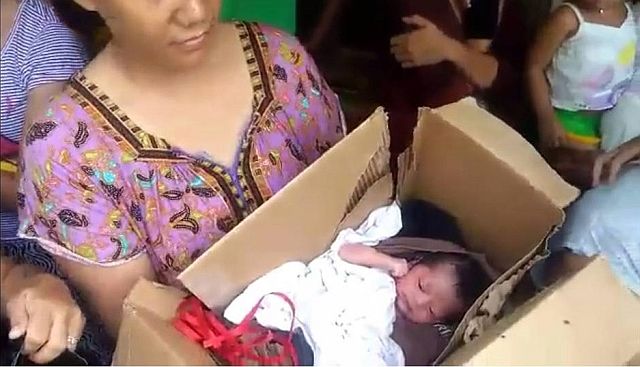 Musa Ursal shows the baby in the box found at a dumpsite near her store. (CDN Photo/Norman V. Mendoza)