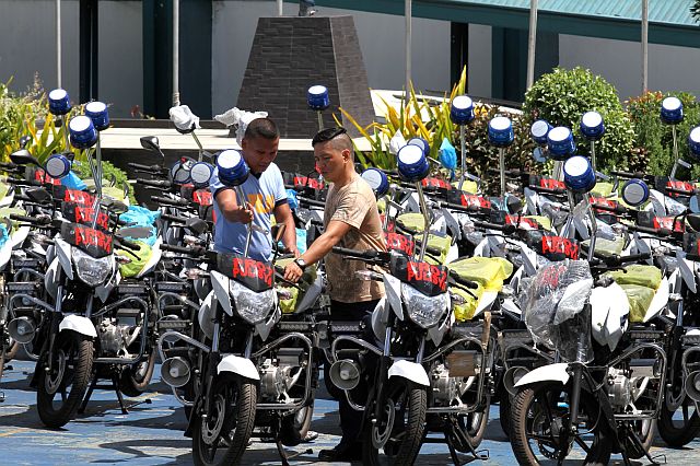Policemen check the 106 motorcycles, which arrived from Camp Crame, at the Central Visayas Regional Police Office in Cebu City. (CDN PHOTO/JUNJIE MENDOZA)