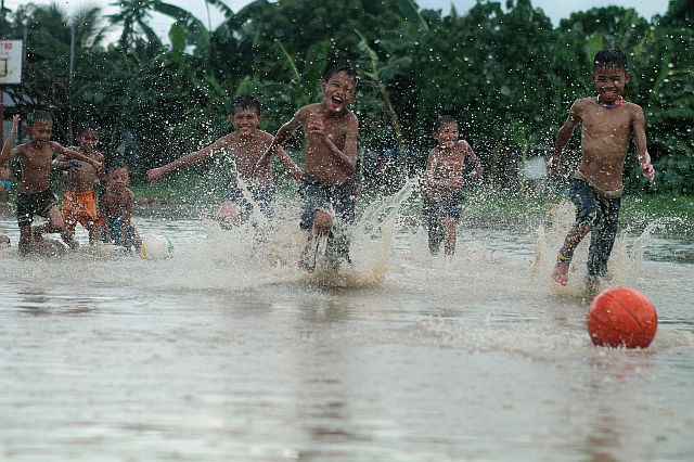 KIDS PLAY. The hassle of flood and traffic that exasperated commuters across Metro Cebu has not touched these kids in Barangay Basak, Lapu-Lapu City who happily spent their rainy Sunday morning playing basketball in a rain pond. (CDN PHOTO/FERDINAND R. EDRALIN)