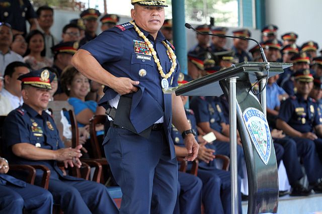 Gun-packing PNP Director General Ronald “Bato” Dela Rosa (at the podium) shows his handgun as he vows to shoot drug lords if he sees them. He spoke before the officers, men and women of the Police Regional Office Central Visayas during his visit at Camp Sergio Osmeña Sr.