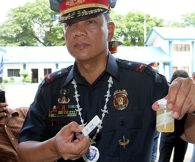 I AM NEGATIVE: Newly installed PRO-7 director Police Chief Supt. Noli Taliño shows results of a drug test conducted on him as he led policemen in a surprise drug test yesterday after the ceremonial change of command at Camp Sergio Osmeña. (CDN PHOTO/JUNJIE MENDOZA)