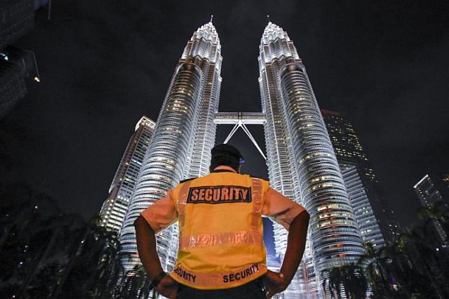 A security guard stands in front of Malaysia’s iconic building, Petronas Twin Towers in Kuala Lumpur, Malaysia in this Jan. 14, 2016 photo.