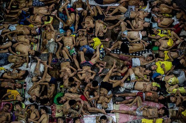 Inmates sleep on the ground of an open basketball court inside the Quezon City jail at night in Manila in this picture taken on July 19, 2016. /AFP 