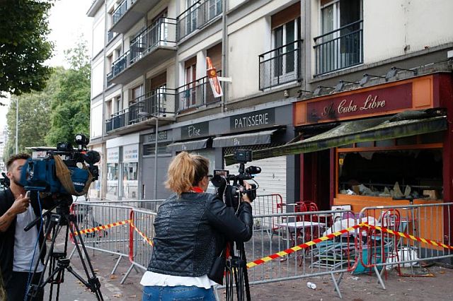 aJournalists gather in front of the fire-damaged Au Cuba Libre bar in Rouen, northern France.