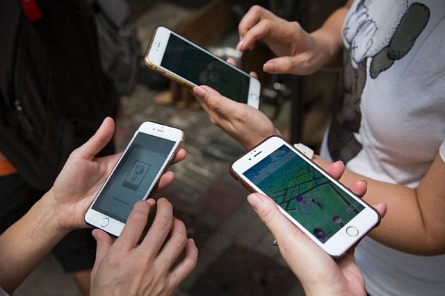 Participants use their smartphones as they play Pokemon Go during a “PokeWalk” in Hong Kong on Saturday.