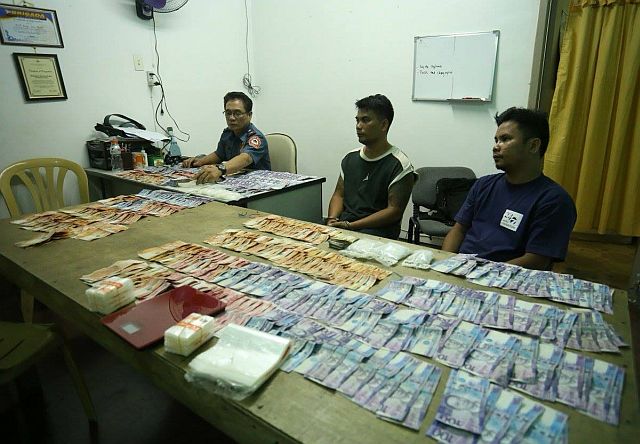 Guadalupe Police Chief Inspector Jose Gesto inspects the confiscated drugs and money estimated to be worth a million (CDN PHOTO/ Lito Tecson)