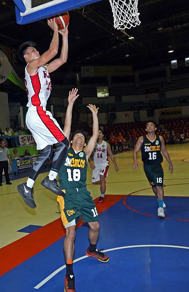 University of San Jose-Recoletos’ Juan Miguel Gastador soars for a lay-up against Gio Laguyo of University of San Carlos in the Cesafi men’s basketball tournament last night at the Cebu Coliseum. (CDN PHOTO/LITO TECSON)
