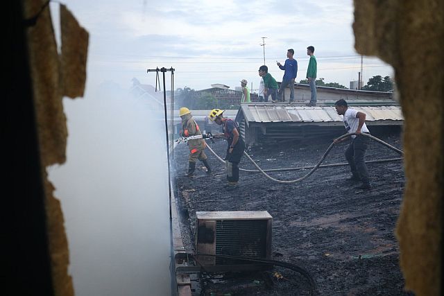 Firemen train their hose at a burning house in Sampaguita, Barangay Banilad, Mandaue City (CDN PHOTO/LITO TECSON)