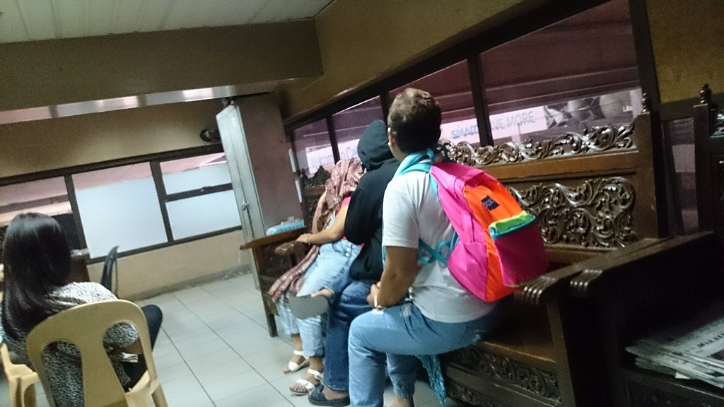Albuera Leyte Mayor Rolando Espinosa Sr.'s sister-in-law Emma sits with a man at the Mactan Cebu International Airport. The man who hid his face turned out to be the mayor's brother Ramon. (CONTRIBUTED PHOTO/GMA 7)