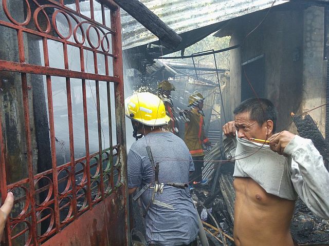 Firemen train their hose at a burning house in Sitio Bamboo, Barangay Pardo. (CDN PHOTO/JUNJIE MENDOZA)