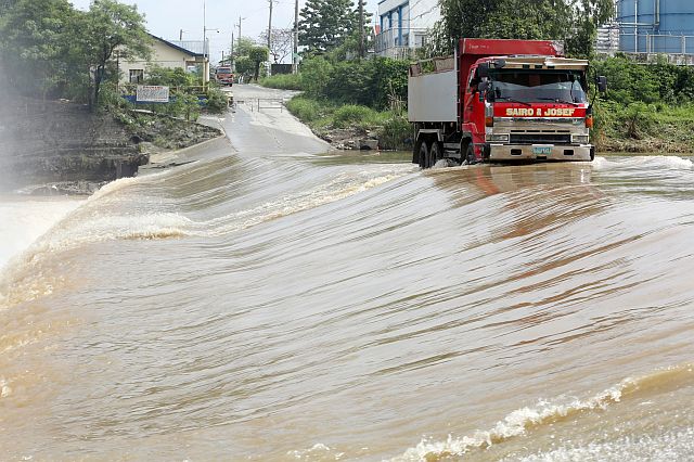 A dump truck plows through a flooded spillway in Barangay San Rafael, Montalban, Rizal. The floodwaters are due to heavy rains caused by habagat, enhanced by Typhoon Dindo. 