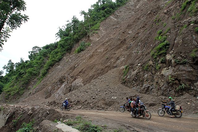 motorcycle riders pass by the Manipis road where the landslide occurred. CDN PHOTO/JUNJIE MENDOZA