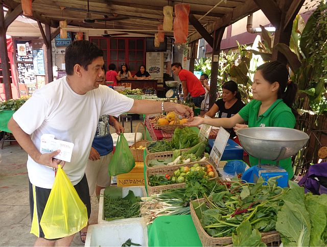 Arden Elca, 49, (left)  buys some vegetable from Dalaguete-based Sergio's Farm, when Cebu Farmers Market was still displaying its produce outside the Handuraw Pizza restaurant in Lahug. (CDN PHOTO/ FRAULINE SISON)