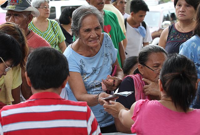 DESPITE the confusion over the venue of distribution, the seniors managed to receive the P2,000 cash aid promised to them by the Cebu City government in Basak San Nocolas, with police securing the venue. At left, BO-PK ally and barangay candidate Reymelio Deleute helps the seniors while Basak San Nicolas chairman Norman Navarro (below) voices his surprise over the change in venue from the Don Vicente Rama Elementary school covered court to the school’s unfinished gym. (CDN PHOTO/JUNJIE MENDOZA)