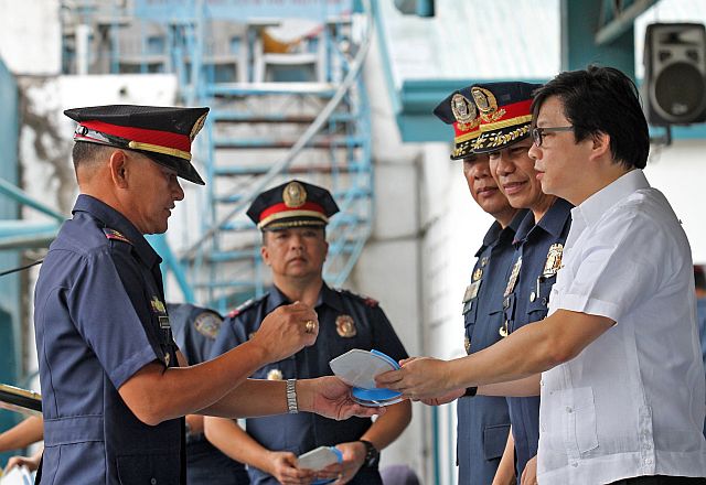 Danao City Police Chief Alejandro Batobalonos receives the best junior police officer in Region 7 award from Presidential Assistant for the Visayas Michael Dino during the 115th police service anniversary celebration. Looking on are Chief Supt. Prudencio “Tom” Bañas, chief of Retirement and Benefits System, and PRO-7 Chief Noli Taliño (2nd and 3rd from right). (CDN PHOTO/JUNJIE MENDOZA)