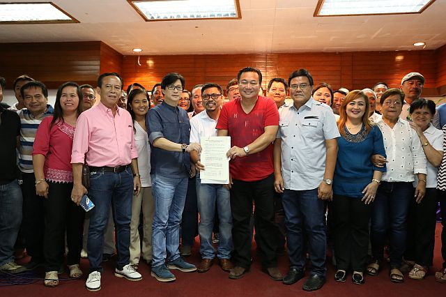 SHOW OF FORCE SANS MIKE: House Speaker Pantaleon  Alvarez (5th from right),  PDP-Laban secretary general, receives the manifesto of support from 65 out of 80 Cebu City barangay captains headed by Philip Zafra (6th from left) and Cebu City Vice Mayor Edgardo Labella,   assisted by Presidential Assistant for the Visayas  Michael Dino, in an event prior to the oath taking of some 300 new members of the ruling party held at the  Sacred Heart Center. Story on page 2. (CDN PHOTO/JUNJIE MENDOZA)