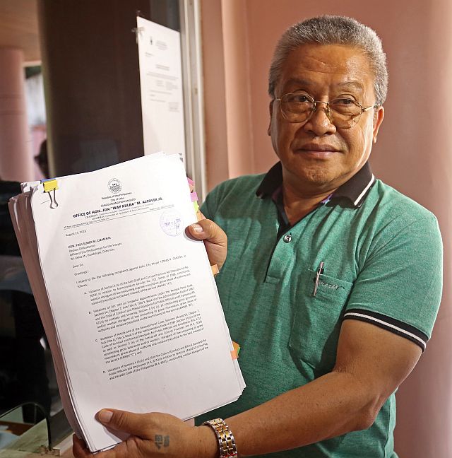    COUNCILOR Pastor “Jun” Alcover Jr. shows his complaint papers to the media prior to  filing four  graft  cases against Cebu City Mayor Tomas Osmeña. (CDN PHOTO/LITO TECSON)