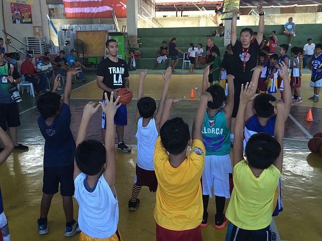 LA Tenorio (with basketball) teaches a group of children the proper shooting form in yesterday’s TM Basketball Para Sa Bayan clinic at the Barangay Tinago Gym, Cebu City. (CDN PHOTO/CALVIN D. CORDOVA)
