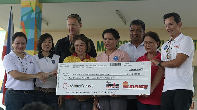 Officials of Sunrise Events Inc. and the Children’s Hour Foundation turn over the P250,000 check to principal Rebecca Toring for the benefit of Marigondon Elementary School students.  (CDN PHOTO/DAFNE WENCESLAO)