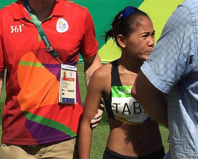 Cebuana Mary Joy Tabal is escorted to the medical tent shortly after finishing her first Olympic marathon race. (Inquirer photo/Ted S. Melendres)