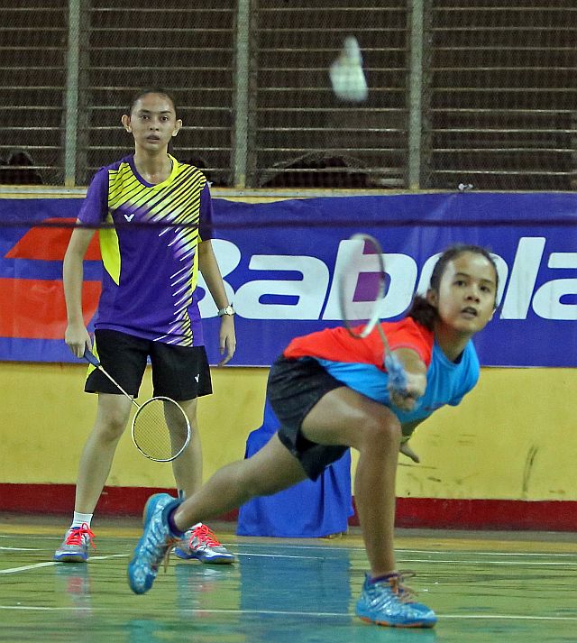 Zinah Marichelle Bejasa returns a shot while her  teammate Elloise Marie Canillo looks on in one of the games in the 2nd Freedom Cup badminton tournament at the Cebu City Sports Center. (CDN PHOTO/LITO TECSON)