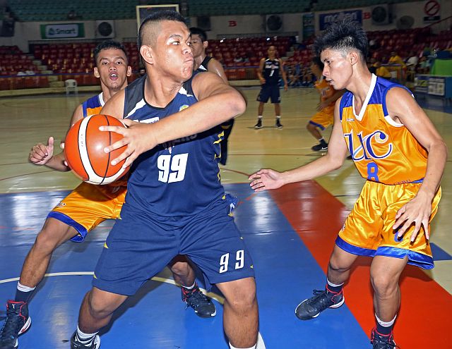 USPF’s Joseph Ducay protects the ball against Aaron Franco of the UC Baby Webmasters in the juniors match of the 16th Cesafi basketball tournament yesterday at the Cebu Coliseum. (CDN PHOTO/LITO TECSON)