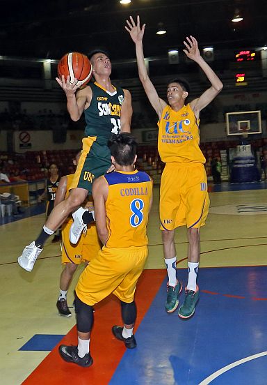 Jules Langres of the USC Warriors goes for a lay-up against Peter Paul Codilla of the UC Webmasters during their 16th Cesafi men’s basketball game at the Cebu Coliseum. (CDN PHOTO/LITO TECSON)