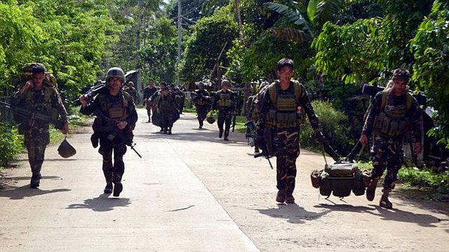 Soldiers walk along a highway as they return to camp after an armed encouter with members of militant group Abu Sayyaf at the village of Bongkaong, Patikul town, Sulu province on the southern island of Mindanao in this August 26, 2016 photo.(/Inquirer.net) 
