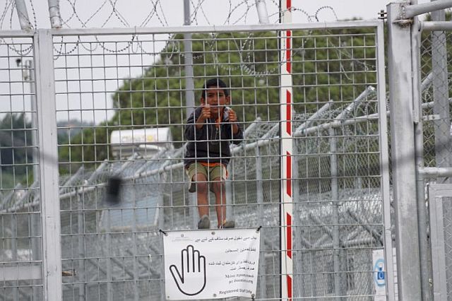 A child looks through the fence at the Moria detention camp for migrants and refugees at the island of Lesbos.