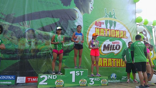 Karla Cosep (first placer), Rue Reinhardt Pañibon (second) and Rona Lacanlale (third) receive their trophies in the 10-kilometer race of the 40th National Milo Marathon Cebu Leg at the Cebu City Sports Center (CCSC). (CDN PHOTO/ GLENDALE ROSAL) 