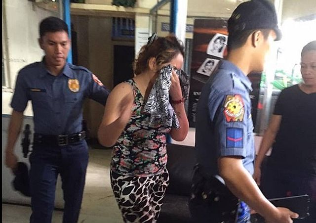 Two policemen arrest Janelle Camacho (center) for dropping a bomb joke at Gaisano Capital South in downtown Cebu City. (CONTRIBUTED PHOTO/ LESLEY CAMINADE OF TV5)