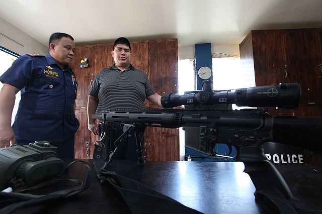 Mandaue City Mayor Luigi Quisumbing, together with  Senior Inspector Alexander Santander of the Special Weapons and Tactic (SWAT), checks on the unit’s equipment as the mayor plans to buy more  trucks, rifles and communication equipment for the city’s  police force (CDN PHOTO/TONEE DESPOJO).