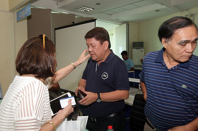 WIFE CARES.  Cebu City Councilor Margot Osmeña wipes the face of husband, Mayor Tomas Osmeña, after he emerged from a meeting with stakeholders affected by the stench coming from the Inayawan dumpsite. At right is City Administrator Bimbo Fernandez (CDN PHOTO/TONEE DESPOJO)