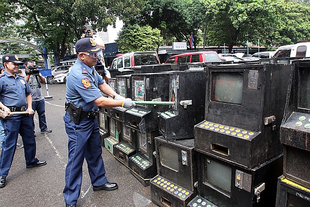 Chief Supt. Noli Taliño, Police Regional Office Central Visayas (PRO-7) chief, and Senior Supt. Joel Doria, Cebu City Police Office chief, lead the destruction of 102 confiscated illegal gambling machines at the CCPO in Camp Sotero Cabahug. (CDN PHOTO/JUNJIE MENDOZA)
