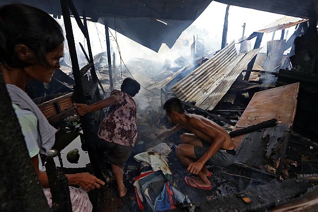 Victims of the Talisay City fire look for things that they can salvage from their razed house. (CDN PHOTO/JUNJIE MENDOZA)