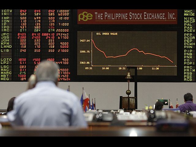 A trader looks at the electronic board showing a downward graph at the Philippine Stock Exchange (PSE) in Makati, Philippines in this August 2011 file photo. (AP FILE PHOTO)