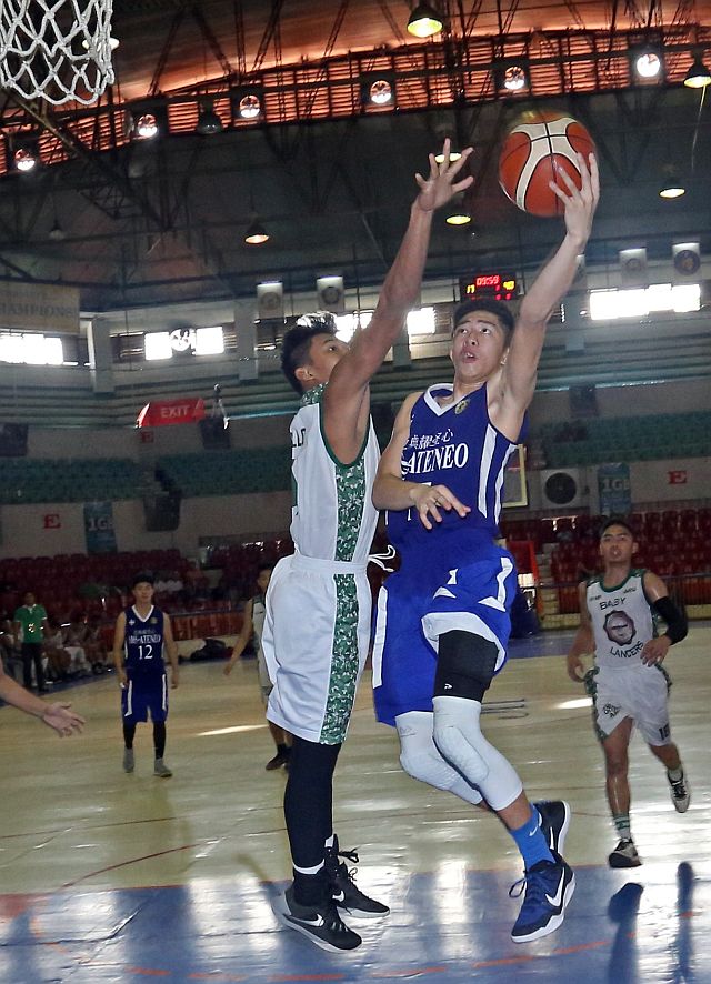 Jed Cedrick Colonia of Sacred Heart School-Ateneo de Cebu stretches for a layup against a University of the Visayas defender in their juniors match of the 2016 Cesafi basketball tournament at the Cebu Coliseum yesterday (CDN PHOTO/LITO TECSON).