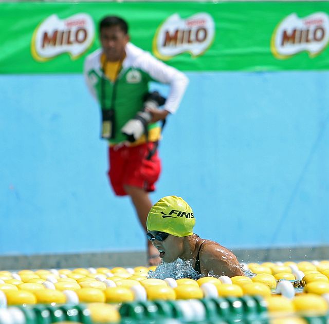 RACE YOU TO THE FINISH. A photographer tries to catch up with Kalibo Sun Yat Sen School’s  Kyla Soguilon to get a better shot of the swimmer who logged four new meet records in the Milo Little Olympic Visayas Regional Finals at the Cebu City Aquatics Center. (CDN PHOTO/LITO TECSON)