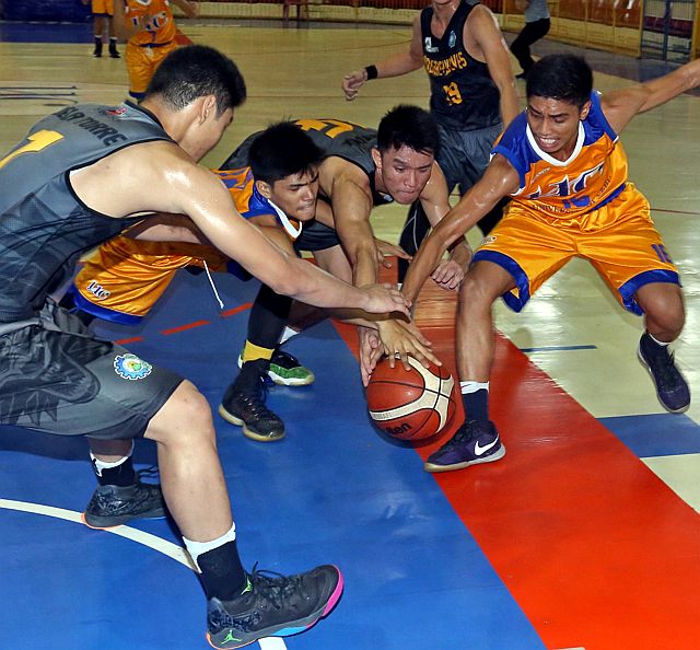 Players of the University of Cebu and Don Bosco fight for the ball in the secondary match of the 16th Cesafi basketball tournament yesterday at the Cebu Coliseum. UC won the match, 69-60. (CDN PHOTO/LITO TECSON)