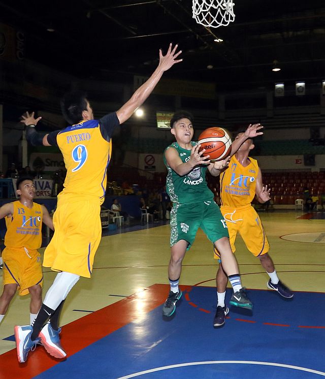  University of the Visayas’ Sheldon Gahi drives to the basket against two University of Cebu defenders in the 16th Cesafi men’s basketball tournament at the Cebu Coliseum (CDN PHOTO/LITO TECSON).
