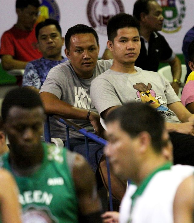 Roger Ray Pogoy (seated right) watches a game between Southwestern University and University of the Visayas at the Cebu Coliseum (CDN PHOTO/JUNJIE MENDOZA).