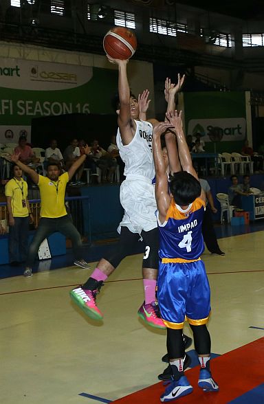 TEAM DEFENSE. Don Bosco’s JB Damolo goes for a floater in the face of University of Cebu’s defense, which apparently includes Baby Webmasters head coach Joever Samonte (background). (CDN PHOTO/LITO TECSON)