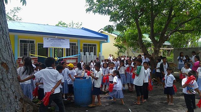Zaragosa school students wait for the start of the turnover of the new classrooms by Capitol officials (CDN PHOTO/NESTLE SEMILLA)