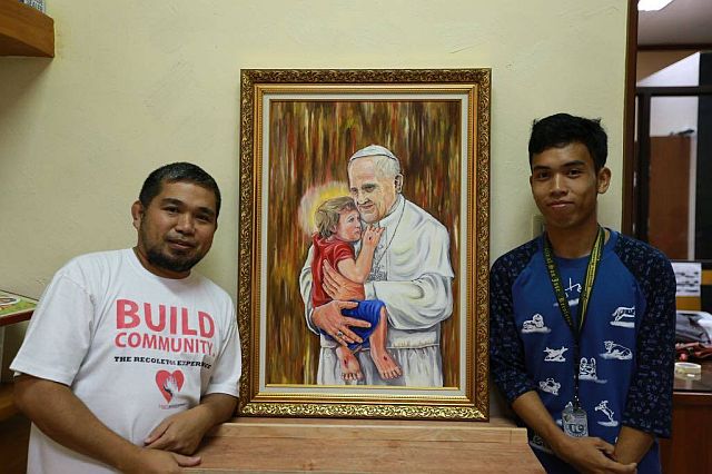Brother Jaazeal Jakosalem and working scholar Melvin Lañas pose with their “Embracing Mercy” painting. (Contributed photo/Bro. Jaazeal Jakosalem, OAR)