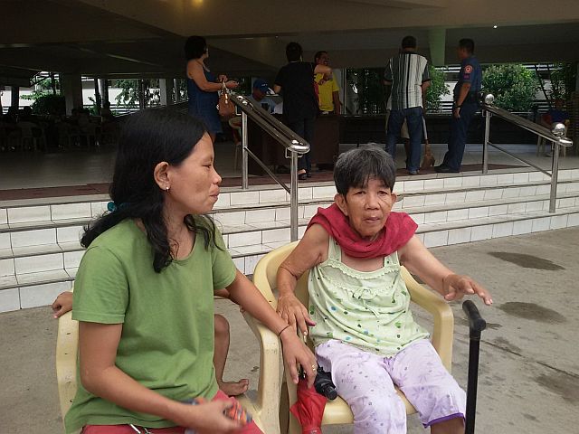 Maria Lumagsao, 67, with daughter Maribel Lumagsao-Bontilao, claimed the financial assistance at Aznar Coliseum (CDN PHOTO/MARGARETTE MANAGAYTAY).