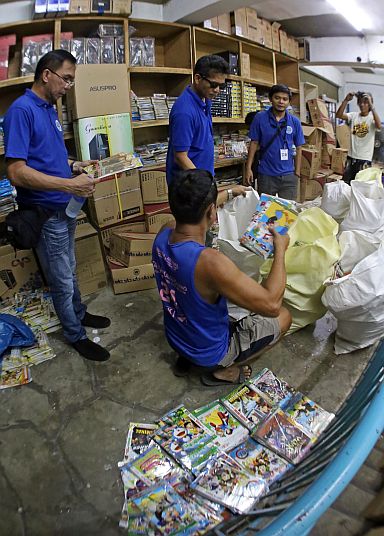 Members of the Optical Media Board will use the pirated discs they confiscated from an appliance store in downtown Cebu City as evidence in filing a case against the owner. (CDN PHOTO/JUNJIE MENDOZA)
