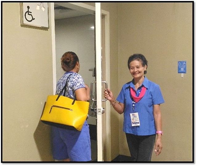 A senior citizen assigned as female restroom assistant greets shopper with a smile. (Contributed Photo)