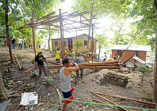 The demolition team had to stop dismantling houses at Osmeña Shrine in Barangay Kalunasan, Cebu City after being questioned by Councilor Pastor Alcover Jr.  (CDN Photo/Lito Tecson)