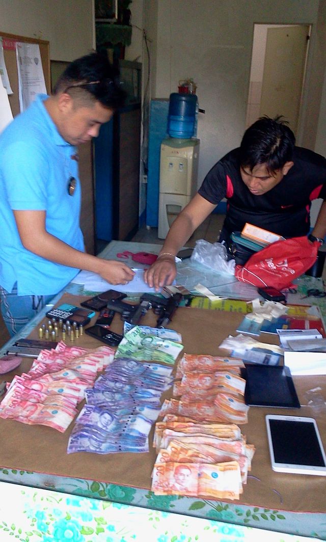 PSI Jomar Medil (left) Chief of Cordova Police Station and PO3 Eleazar Llanes showed the evidences confiscated from the killed High Value Target Jeffrey Daan in Barangay San Miguel Cordova town.(CDN PHOTO/NORMAN MENDOZA)