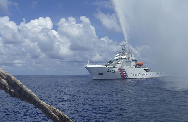 A China Coast Guard vessel approaches Filipino fishermen as they confront each other off Scarborough Shoal in the South China Sea in this Sept. 23, 2015 file photo. (AP)